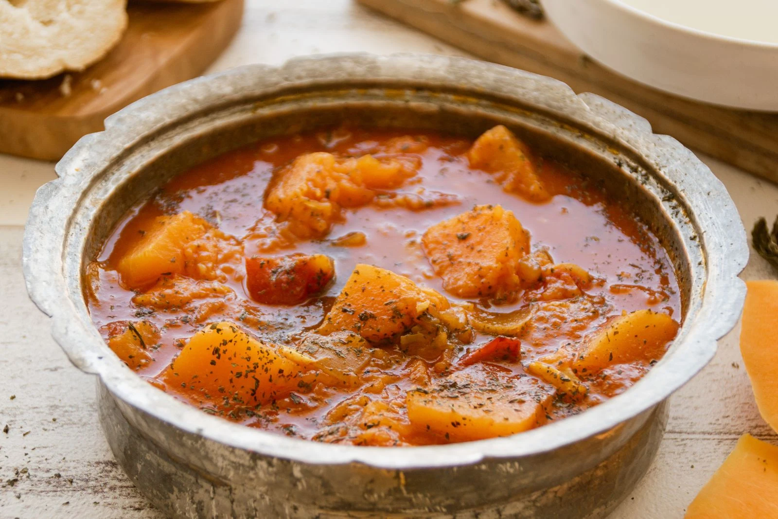 Pumpkin soup in a rustic metal bowl on a table