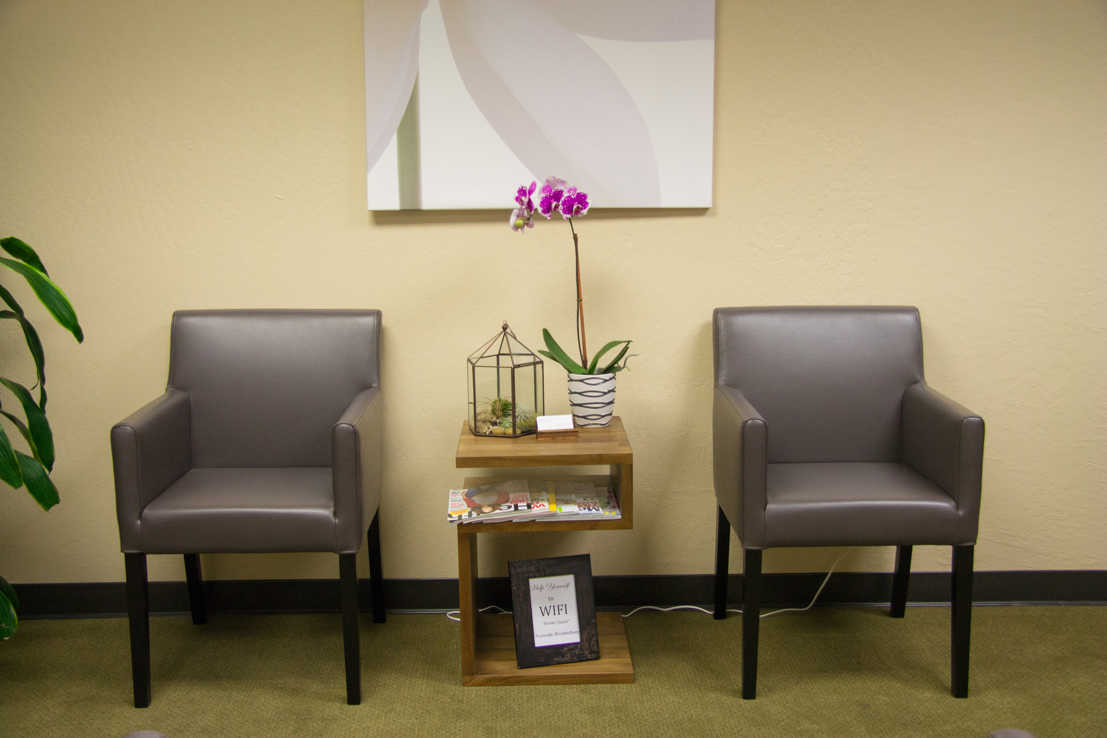 Evoke waiting area with two chairs and an orchid