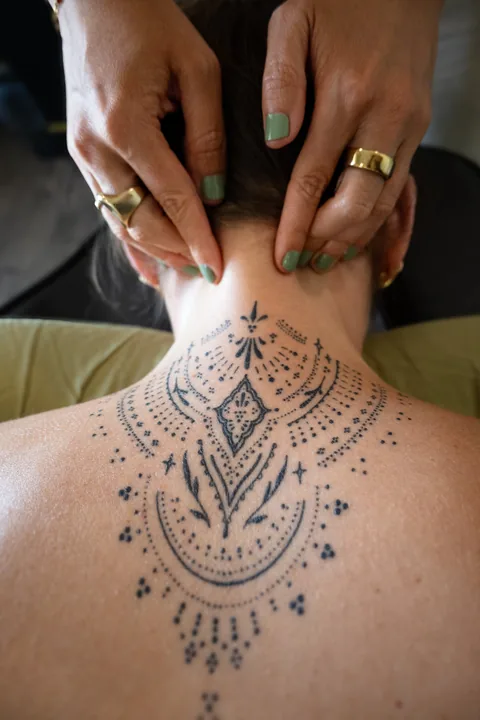 Kristy providing gentle hands-on bodywork at the back of a patient’s neck
